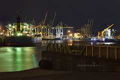 kaiser-wilhelm-hafen Nachts im alten Kaiser-Wilhelm-Hafen in Hamburg. Ein Frachtschiff liegt am Kai. Containerbrücken dahinter. Ein diagonal ins Bild führendes Geländer mit ein paar...