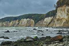 kreidekueste Ein Ausschnitt der malerischen Kreidefelsen auf Rügen. Moosbewachsene Steine am Strandufer und leichter Wellengang auf der Ostsee.