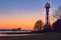 leuchtturm-wittenbergen Der Leuchtturm Wittenbergen in Hamburg Blankenese im Herbst in der Dämmerung nach Sonnenuntergang vor dunkelrotem Abendhimmel. Ein Containerschiff kommt die...