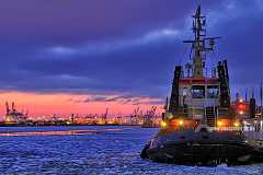 schlepper Ein Schlepper liegt in Hamburger Hafen auf der von Eisschollen bedeckten Elbe. Der abendliche Himmel zu Beginn der blauen Stunde zeigt einen rötlichen Streifen...