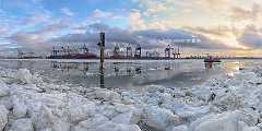 eisstrand An einem sonnigen Wintertag am Elbstrand in Hamburg. Es türmen sich Eisschollen am Strand. Eine Fähre fährt der Sonne entgegen. Im Hintergrund ein...