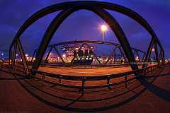 gateway Eine Brücke zur blauen Stunde im Hamburger Hafen deren Träger durch die verwendete Fototechnik zu einem Tor gebogen wurden. Durch diese Öffnung kann man ein...