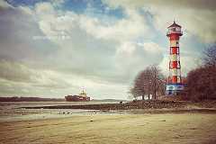 leuchtturm-wittenbergen-retro An einem sonnigen Tag in Wittenbergen am Elbstrand in Hamburg Blankenese fährt ein Containerschiff auf der Elbe. Die Bearbeitung vermittelt einen nostalgisches...